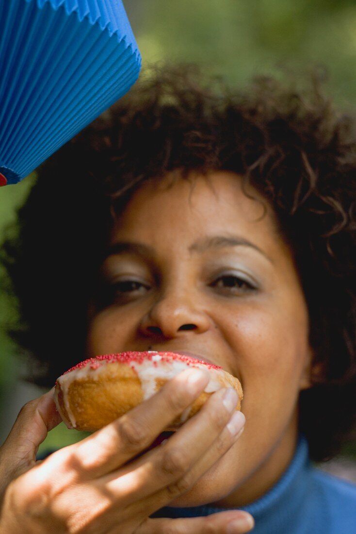 Woman biting into a doughnut (4th of July, USA)