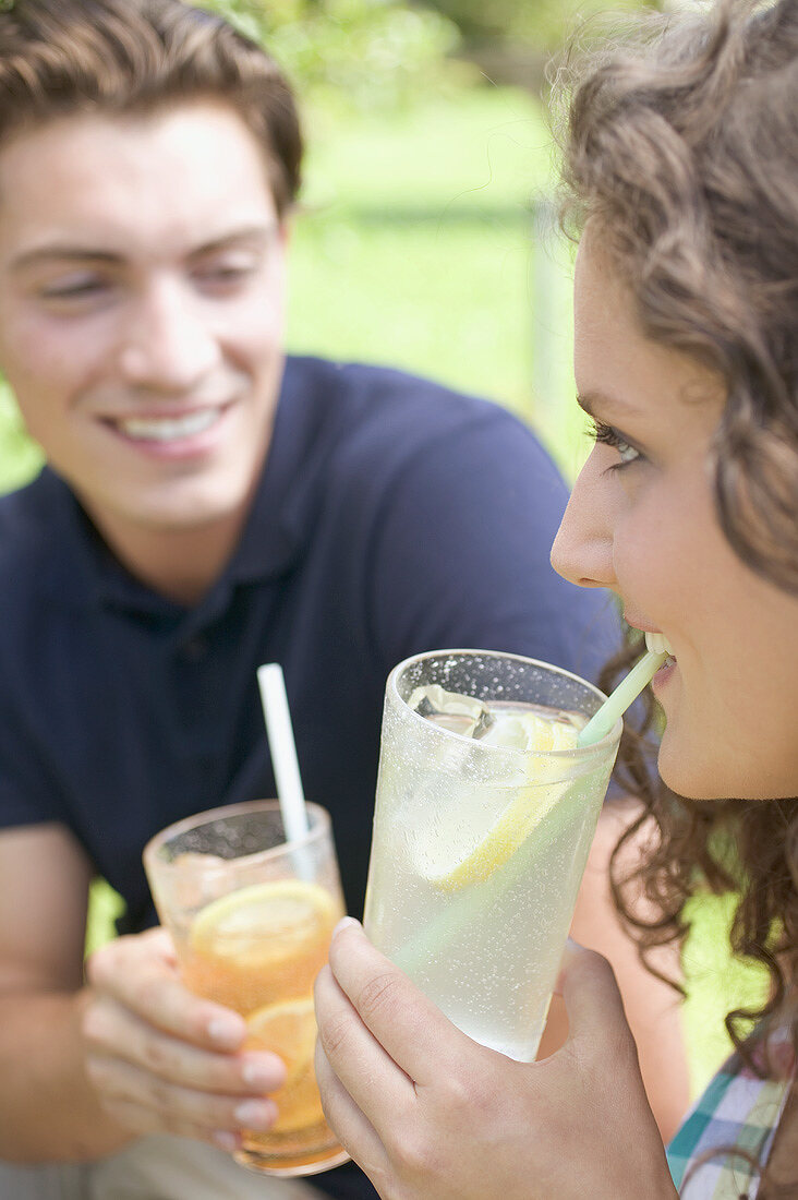 Young couple drinking iced tea and lemonade