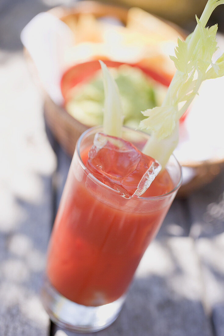 Tomato drink with celery and ice cubes