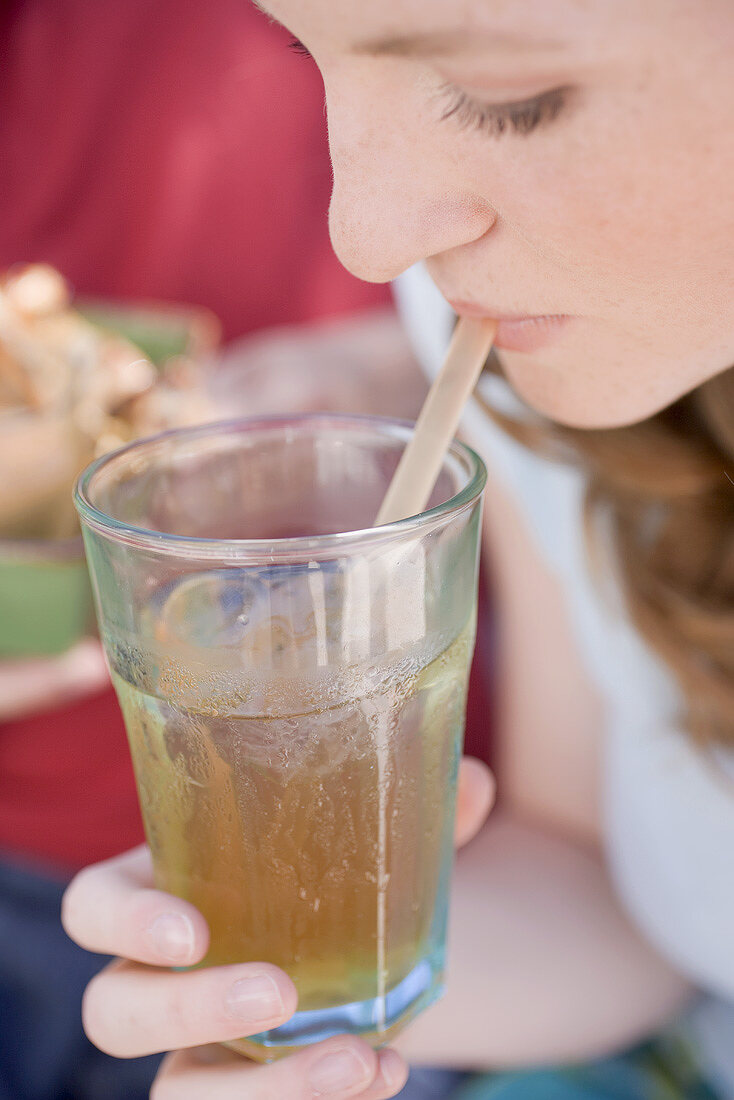 Young woman drinking iced tea through a straw