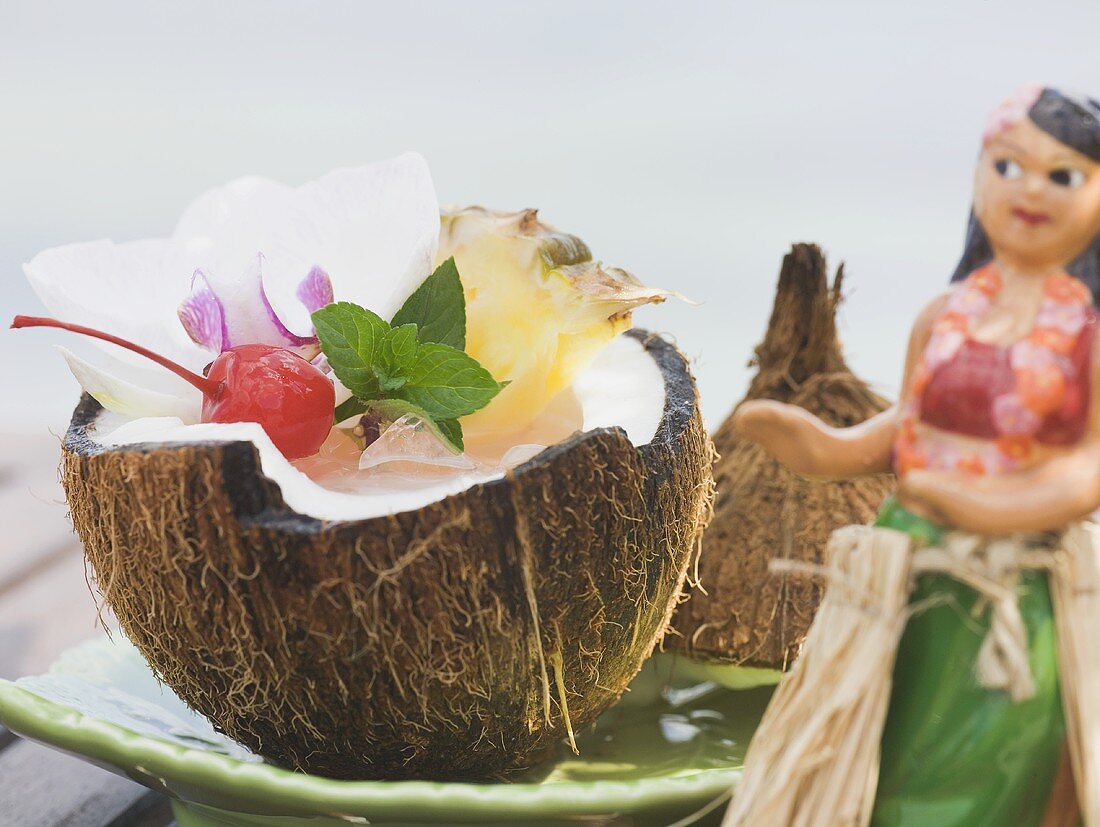 Kokosnussdrink mit Ananas, Cocktailkirsche und Orchidee