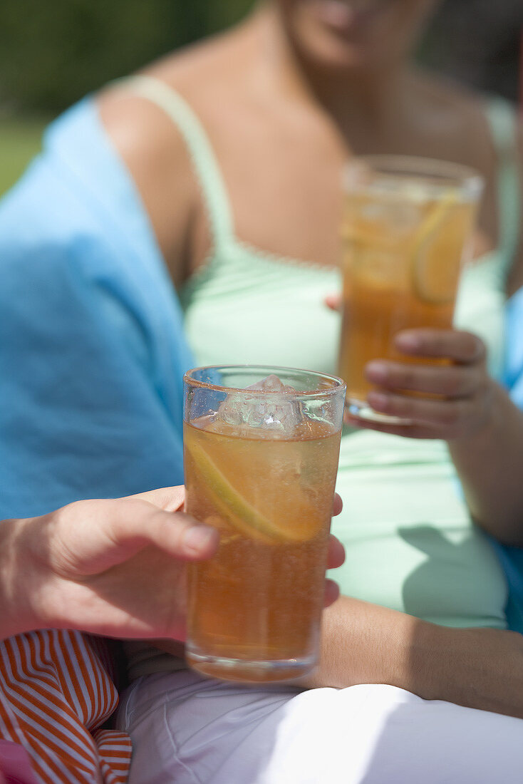 Two women holding glasses of iced tea