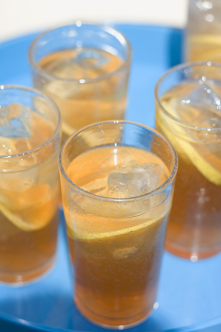 Several glasses of iced tea on a tray