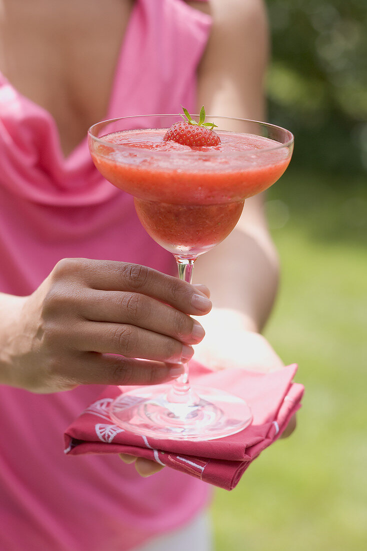 Frau hält fruchtigen Erdbeerdrink im Freien