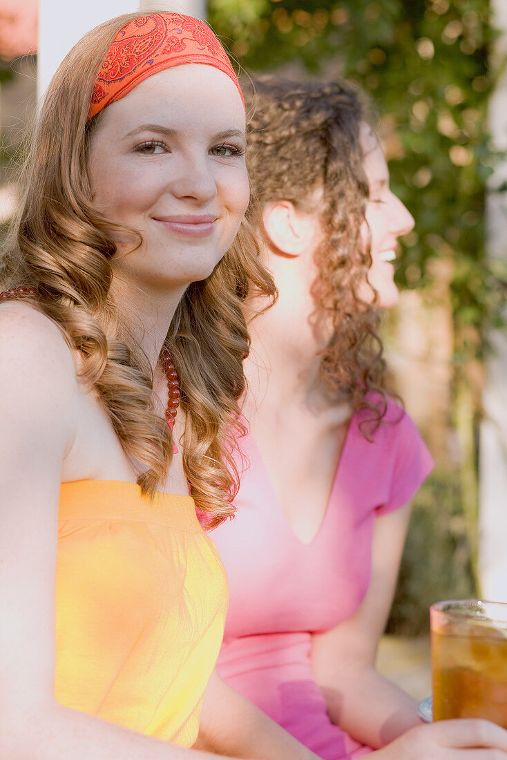 Zwei junge Frauen mit Eistee beim Gartenfest