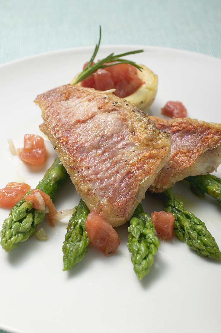Fried red mullet fillets with asparagus and tomatoes