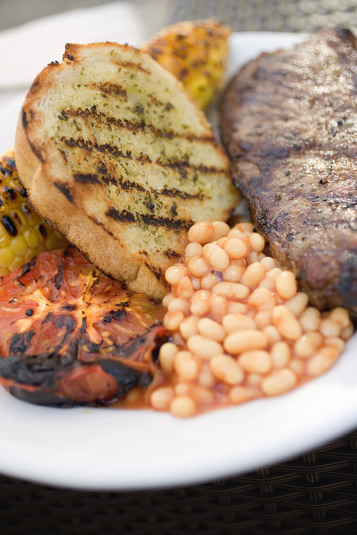 Rindersteak mit Weißbrot, Baked Beans und Grilltomate