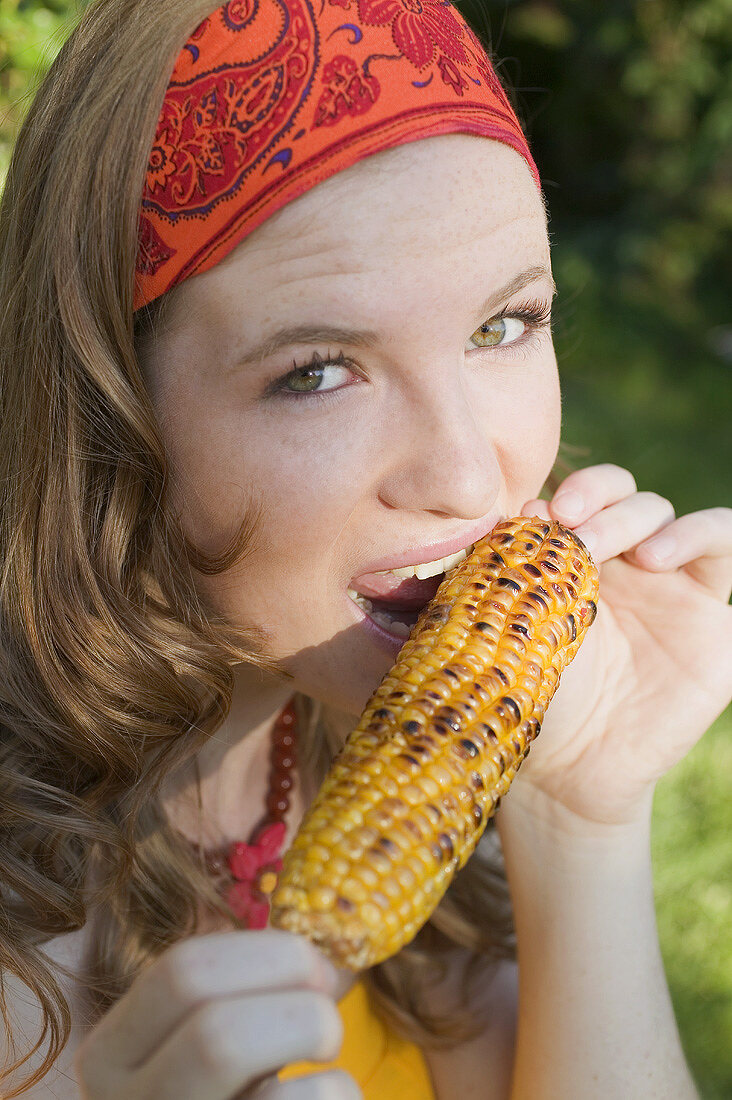 Woman eating grilled corn on the cob