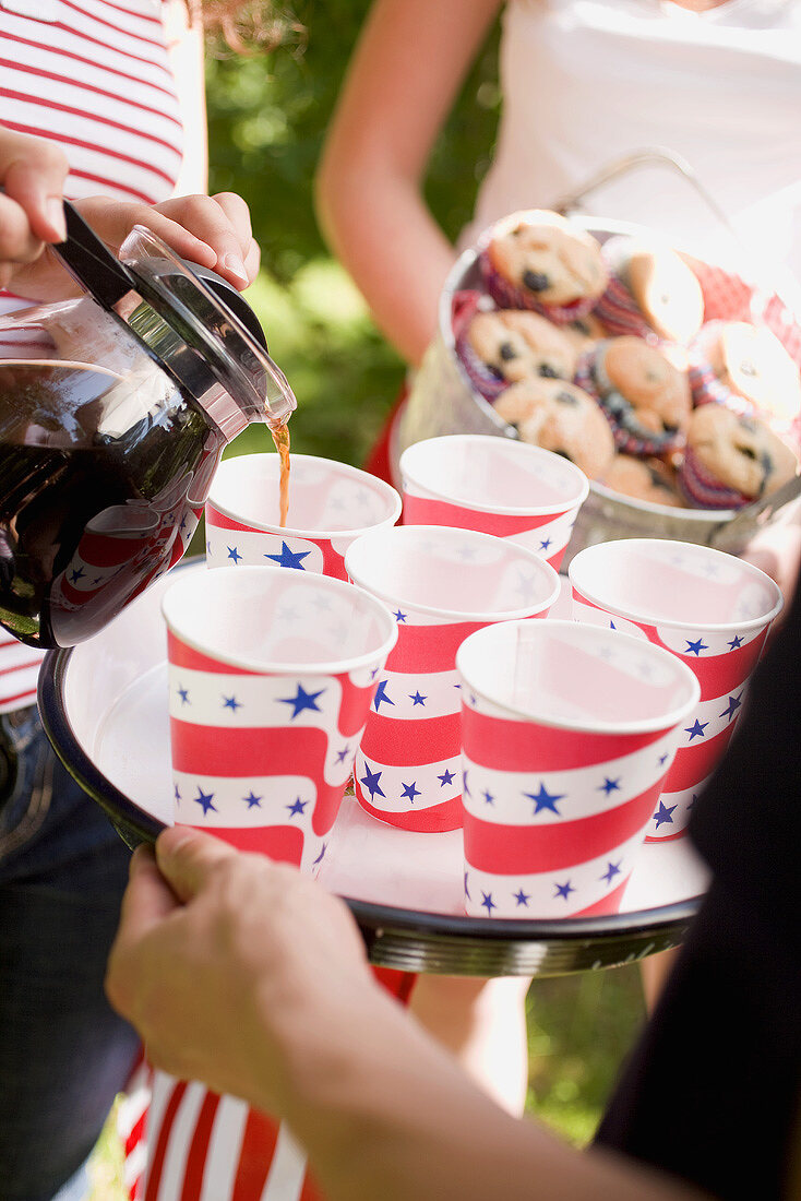 Woman pouring coffee into paper cups (4th of July, USA)