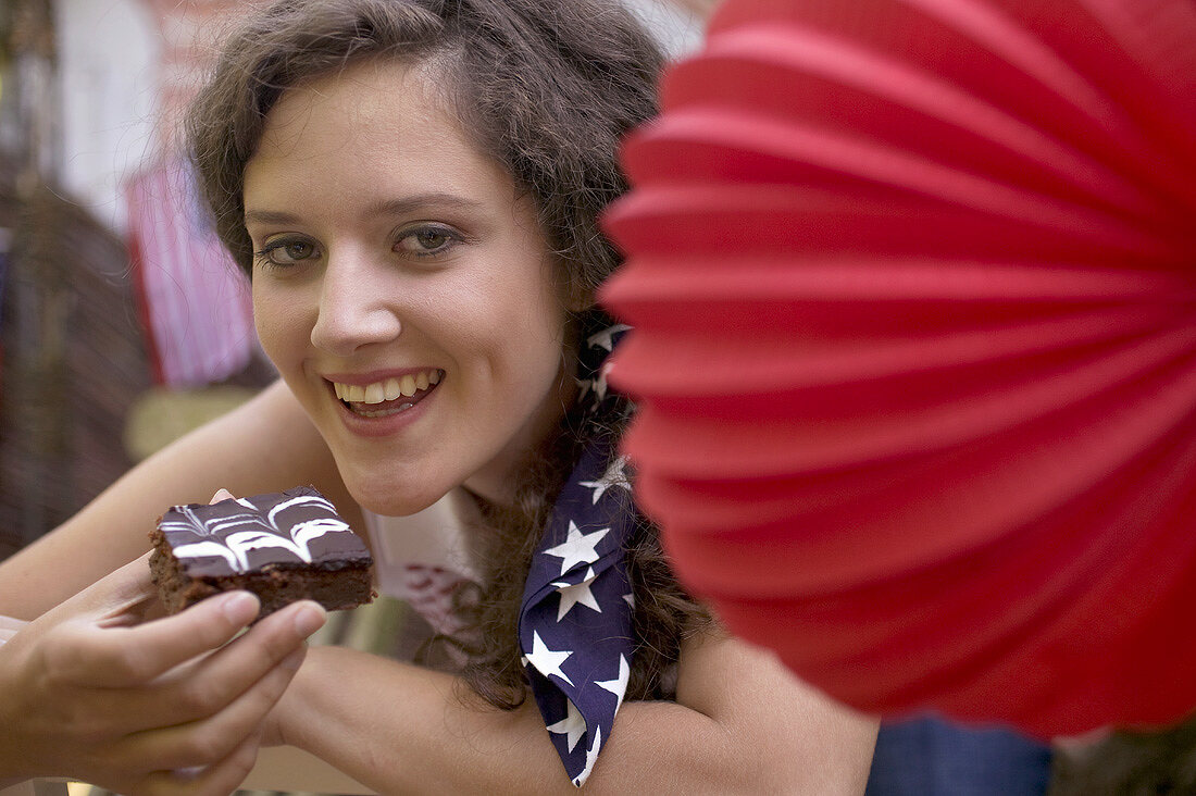 Woman eating a brownie on the 4th July (USA)