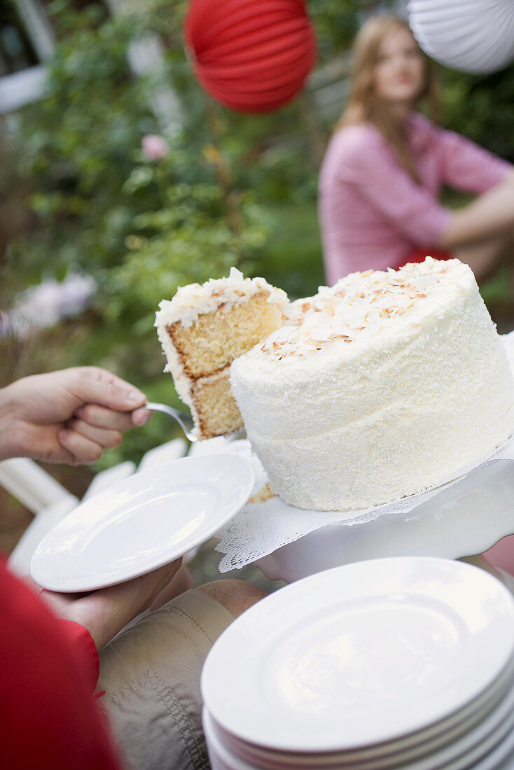 Hand holding piece of coconut cake on server (4th of July, USA)