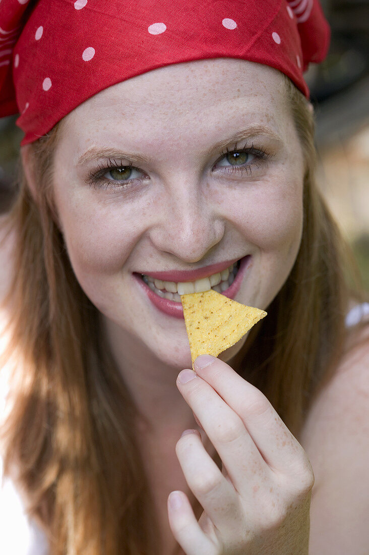 Frau beisst in Tortillachip