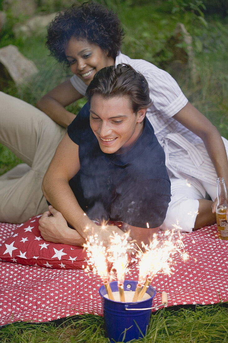 Paar mit Wunderkerzen beim Picknick am 4th of July (USA)