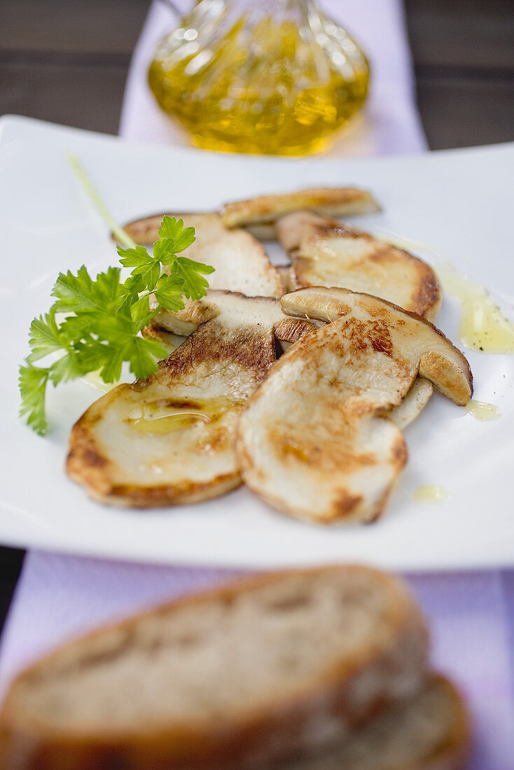 Fried cep slices with parsley, olive oil and bread