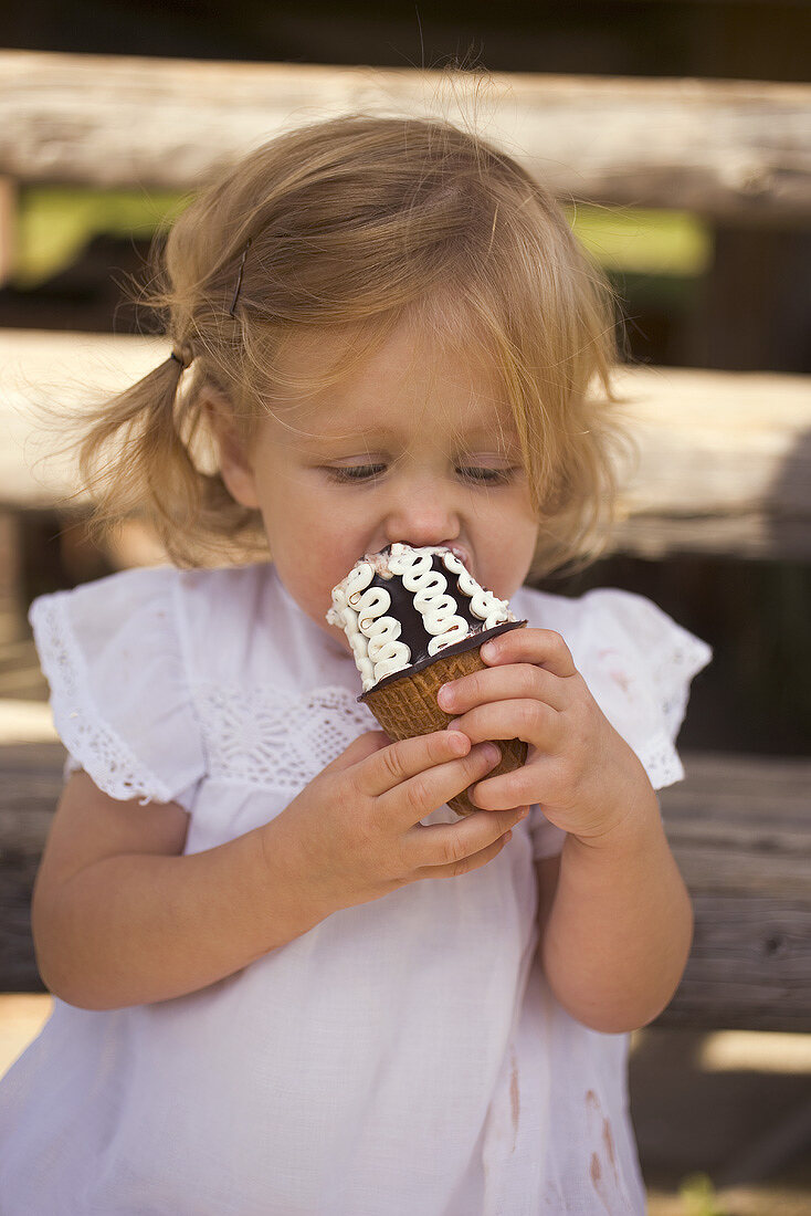 Small girl eating a chocolate ice cream cone