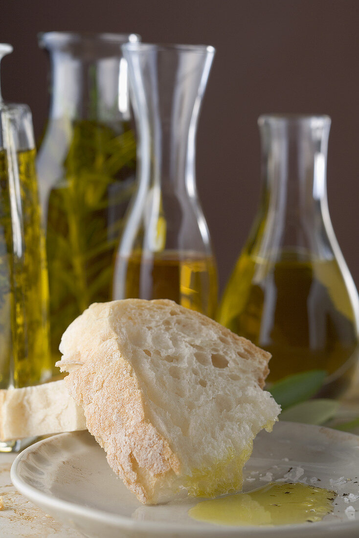 White bread with olive oil, bottles of oil in background