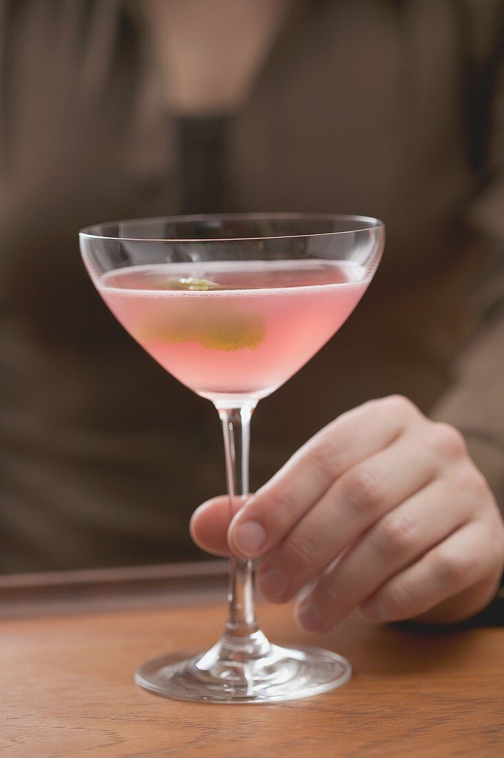 Frau mit Glas rosa Martini mit Olive