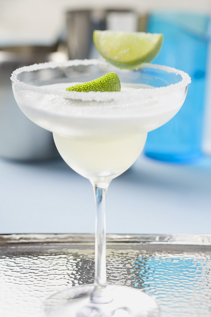 Margarita with lime wedges in a glass with a salted rim