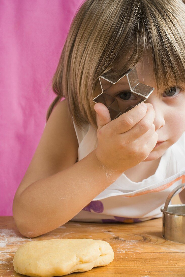 Child peeping through a biscuit cutter