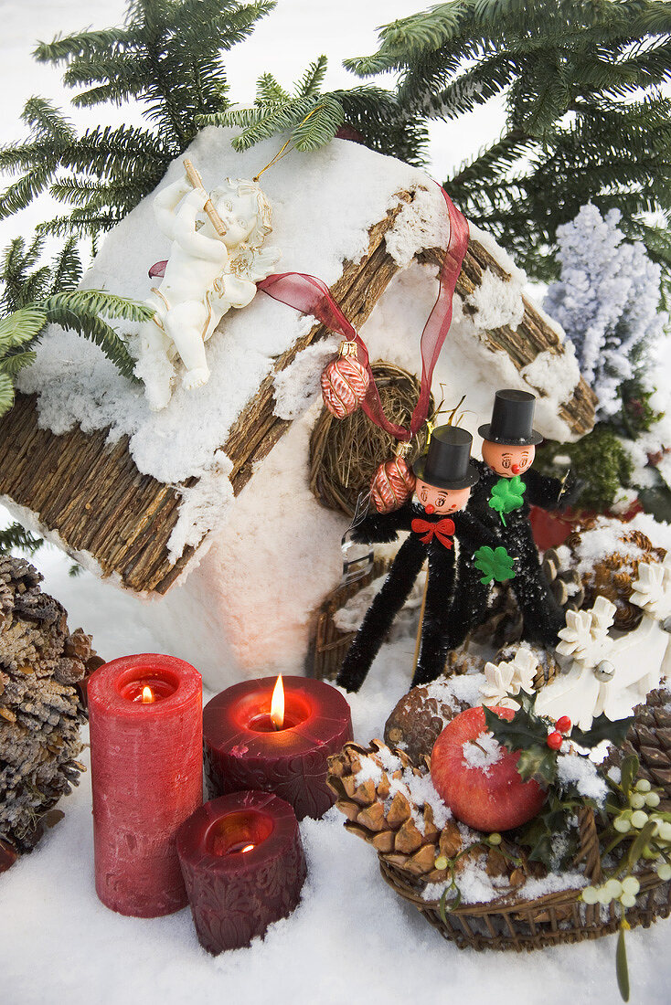 Weihnachtsdeko und zwei Schornsteinfeger im Schnee