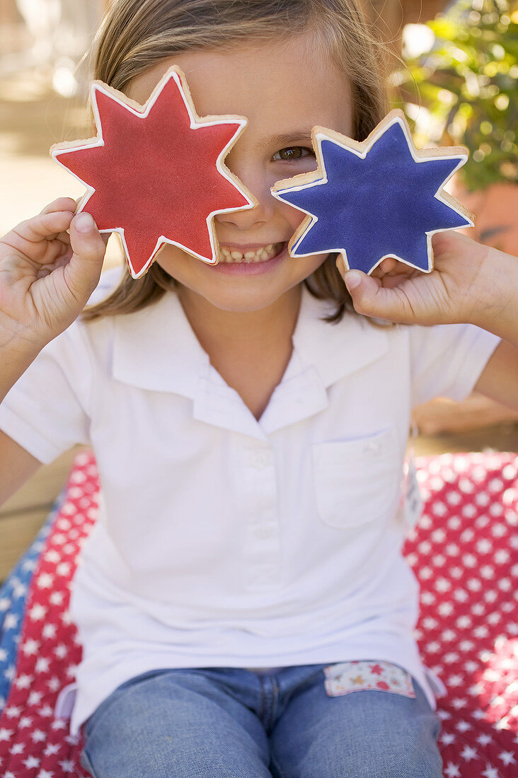 Kleines Mädchen hält zwei Sternplätzchen (4th of July, USA)