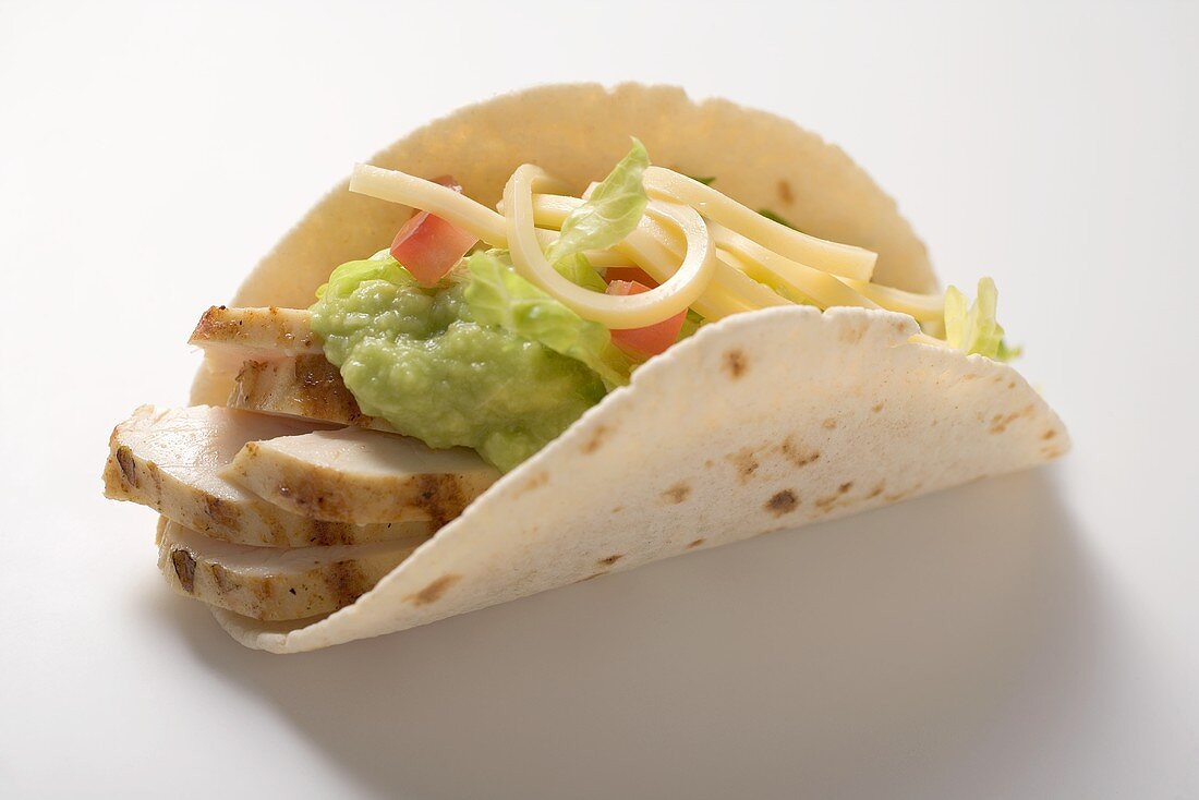 Folded tortilla filled with chicken, guacamole and cheese