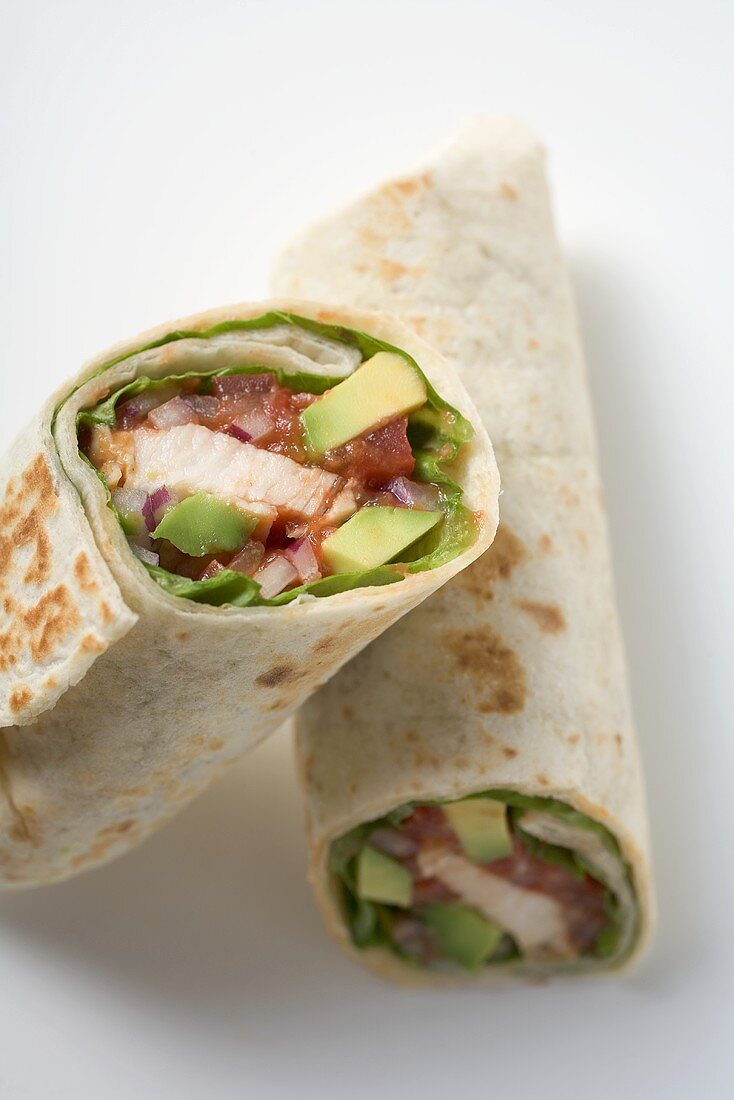 Two wraps filled with chicken and avocado