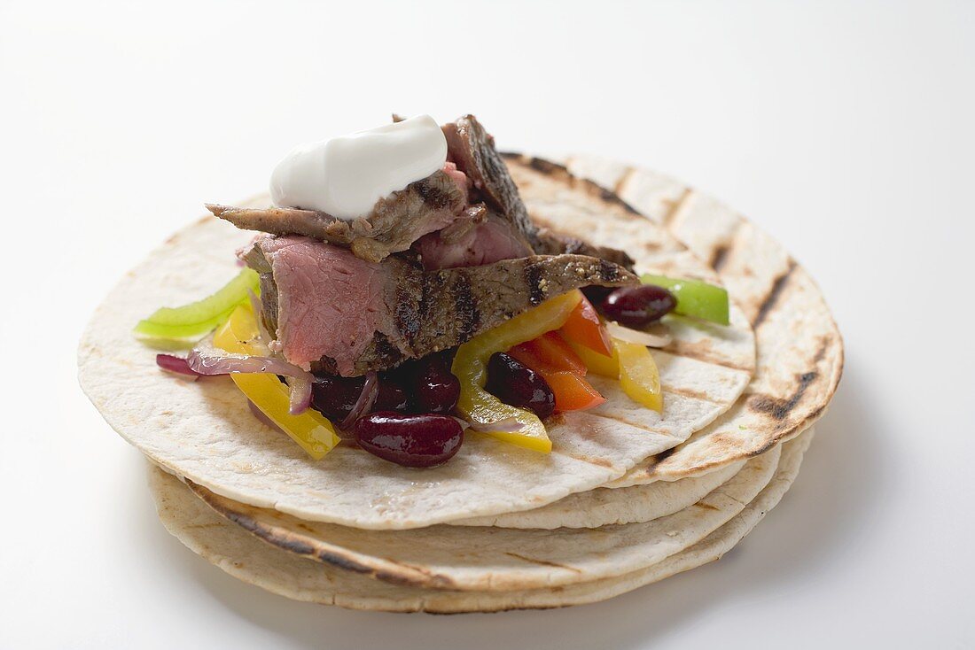 Beef fajita with beans, peppers and sour cream