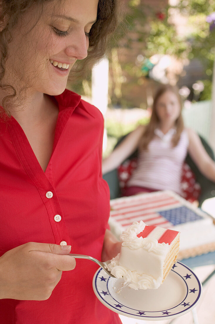 Woman eating a piece of cake on the 4th of July (USA)