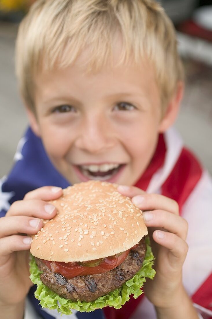 Kleiner Junge hält Hamburger (4th of July, USA)