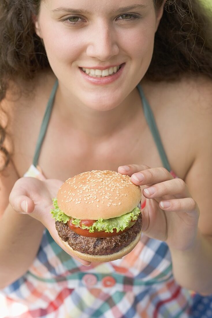 Woman holding hamburger