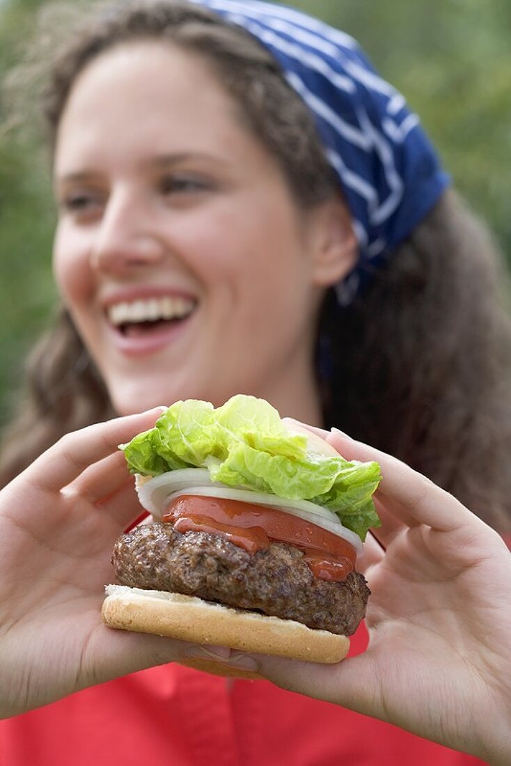 Woman holding large hamburger