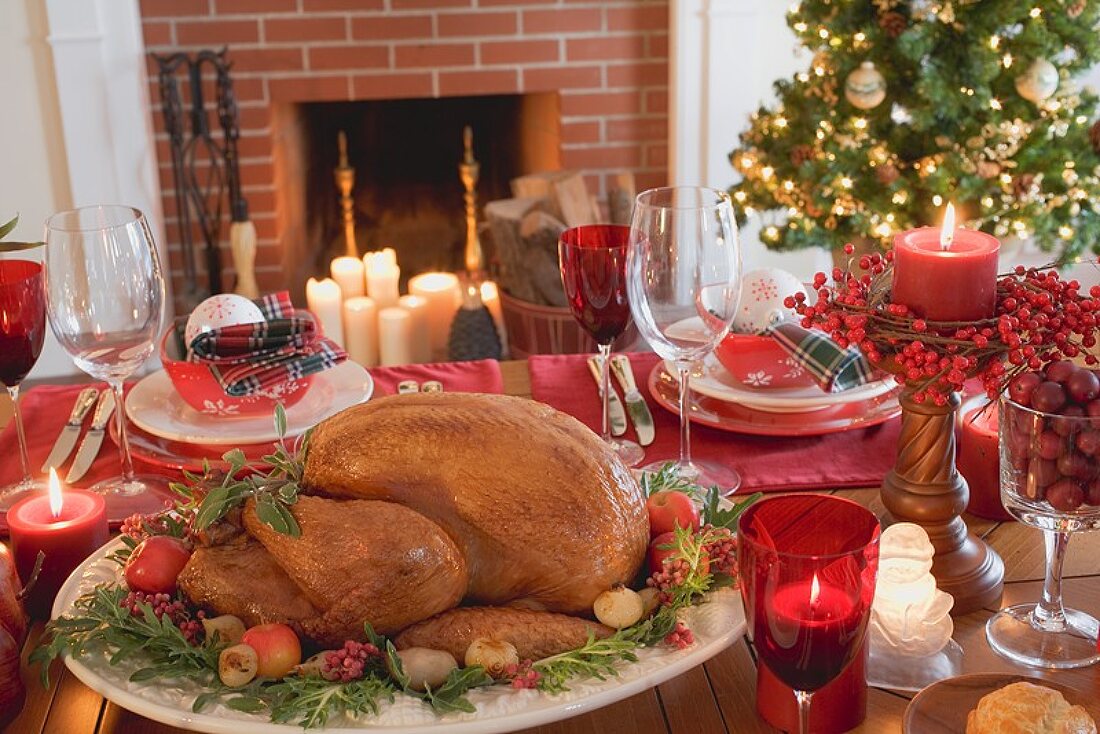 Weihnachtlich gedeckter Tisch mit Turkey vor Kamin (USA)