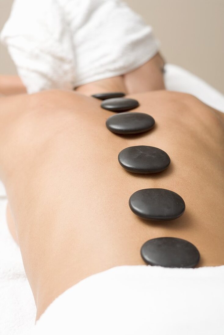 Woman having LaStone Therapy (healing therapy using stones)