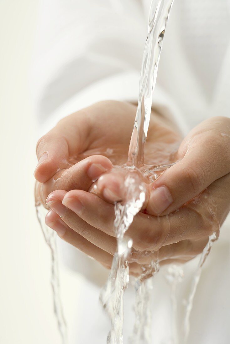 Hände unter Wasserstrahl