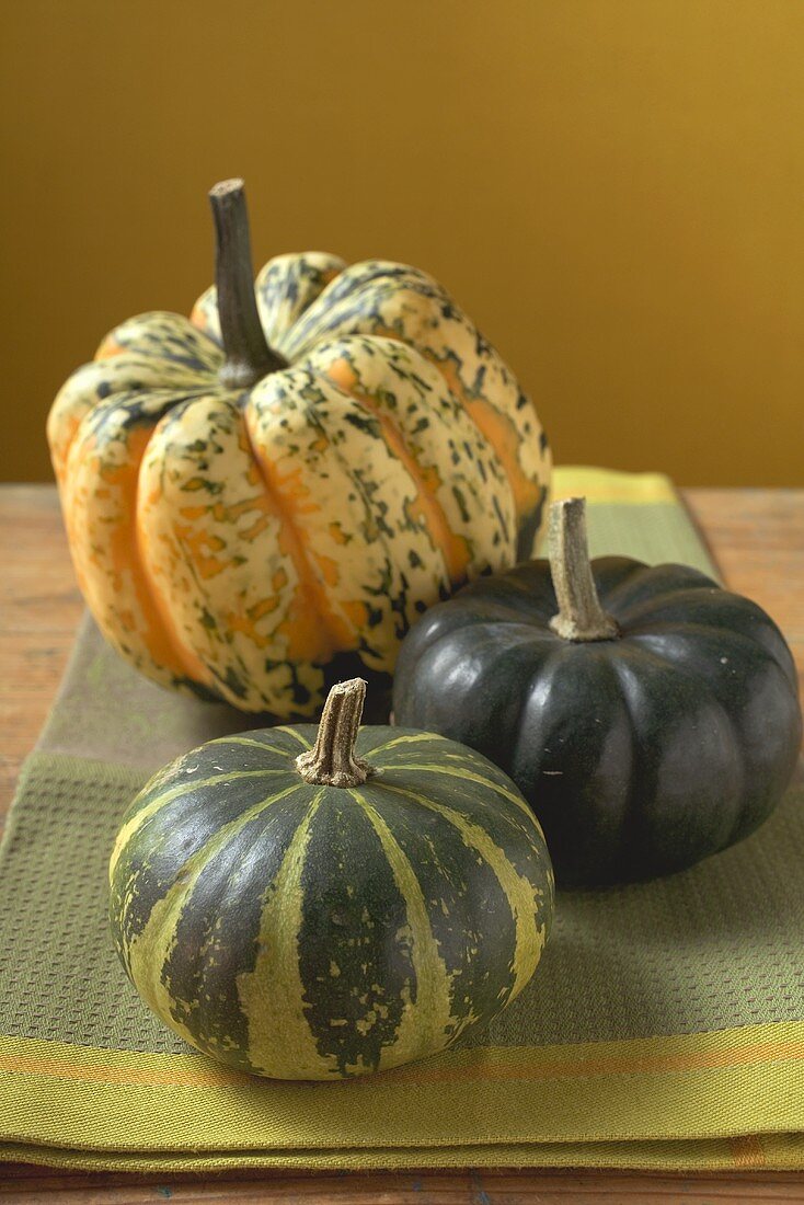 Three different pumpkins on cloth