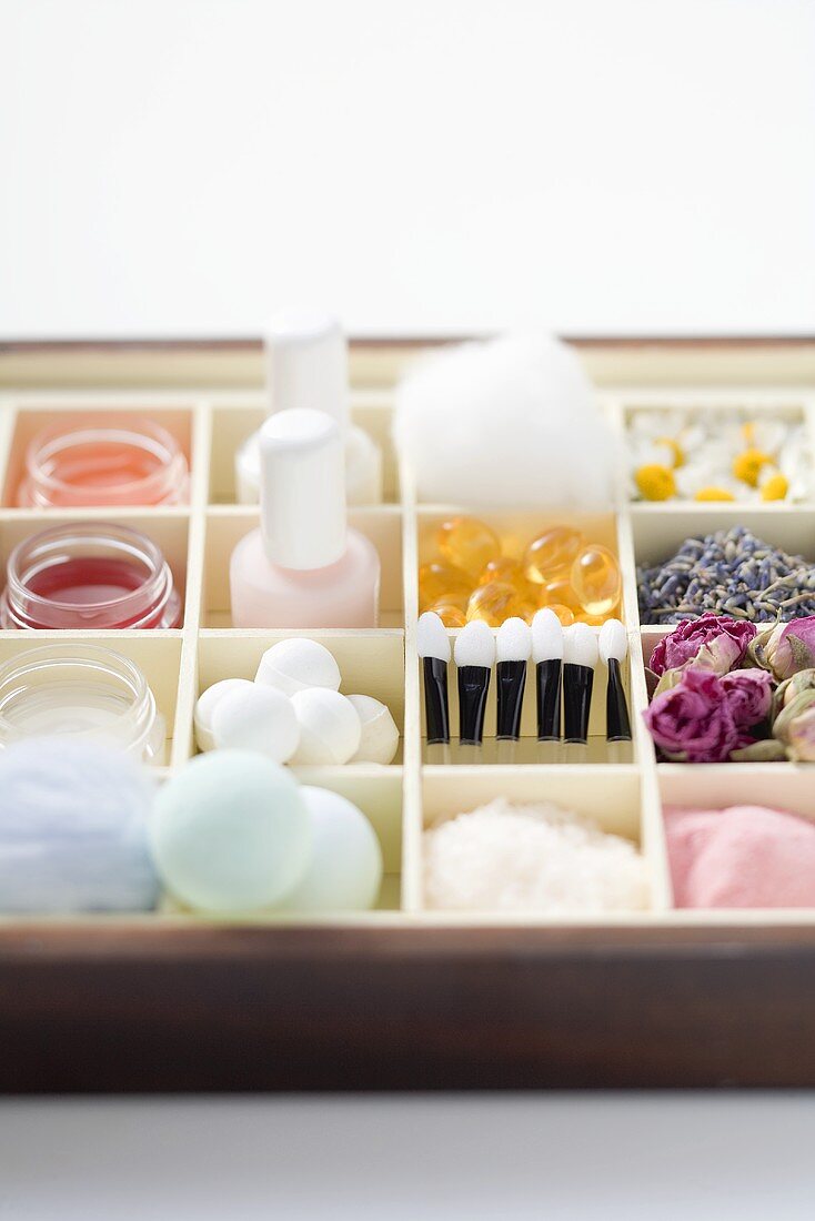 Various beauty products and flowers in type case