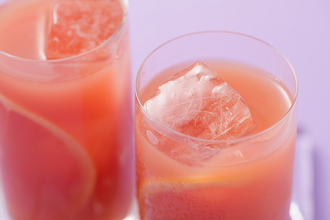 Zwei Gläser rosa Grapefruitsaft mit Eiswürfeln