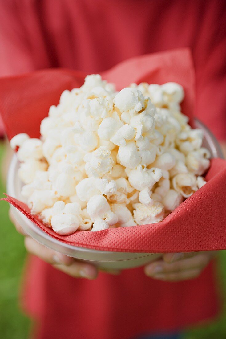Person holding bowl of popcorn