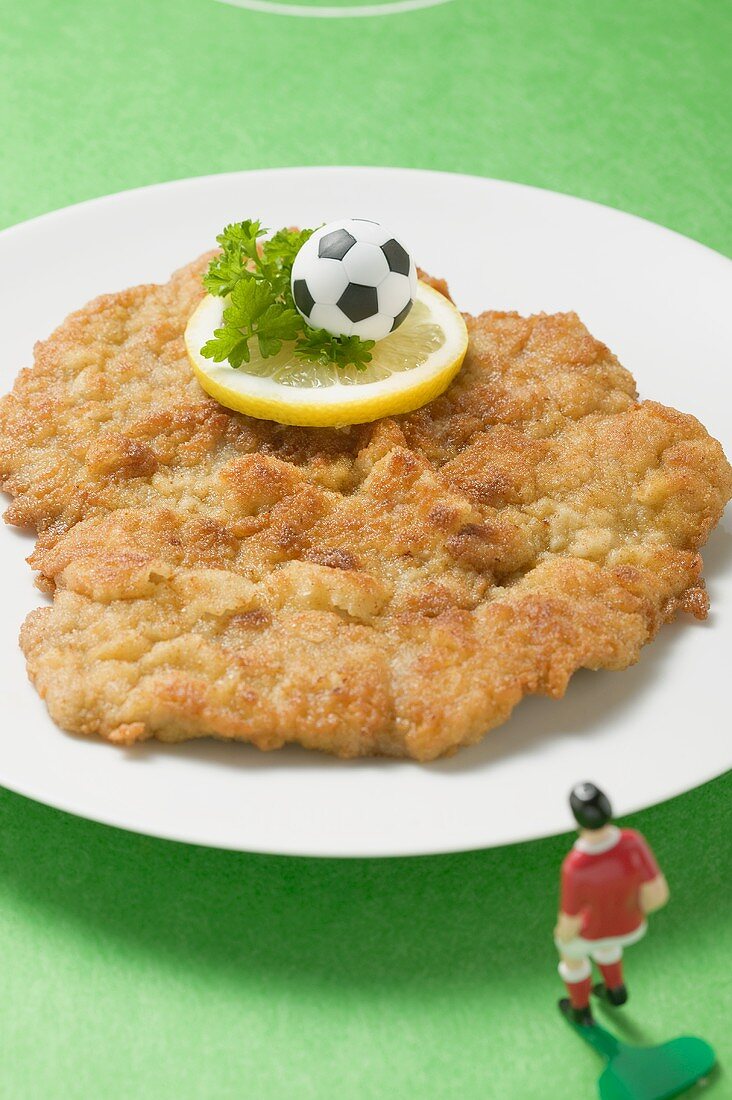 Wiener Schnitzel mit Fussball und Miniaturfussballspieler