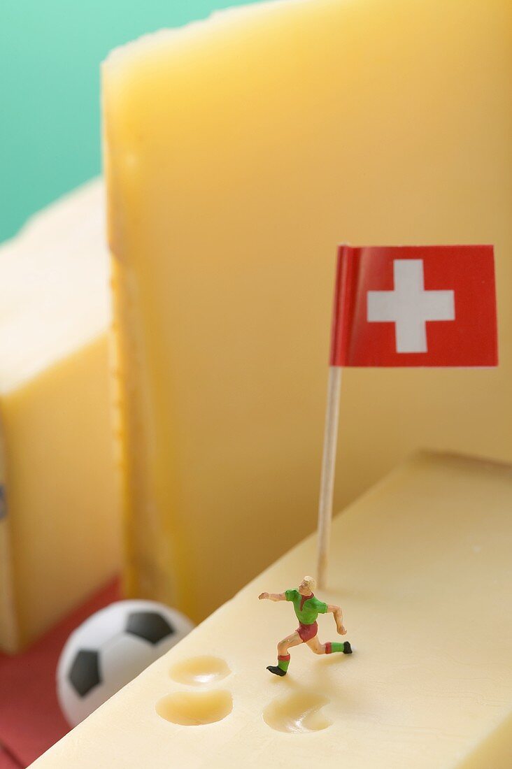 Swiss cheese with football figure, football and flag
