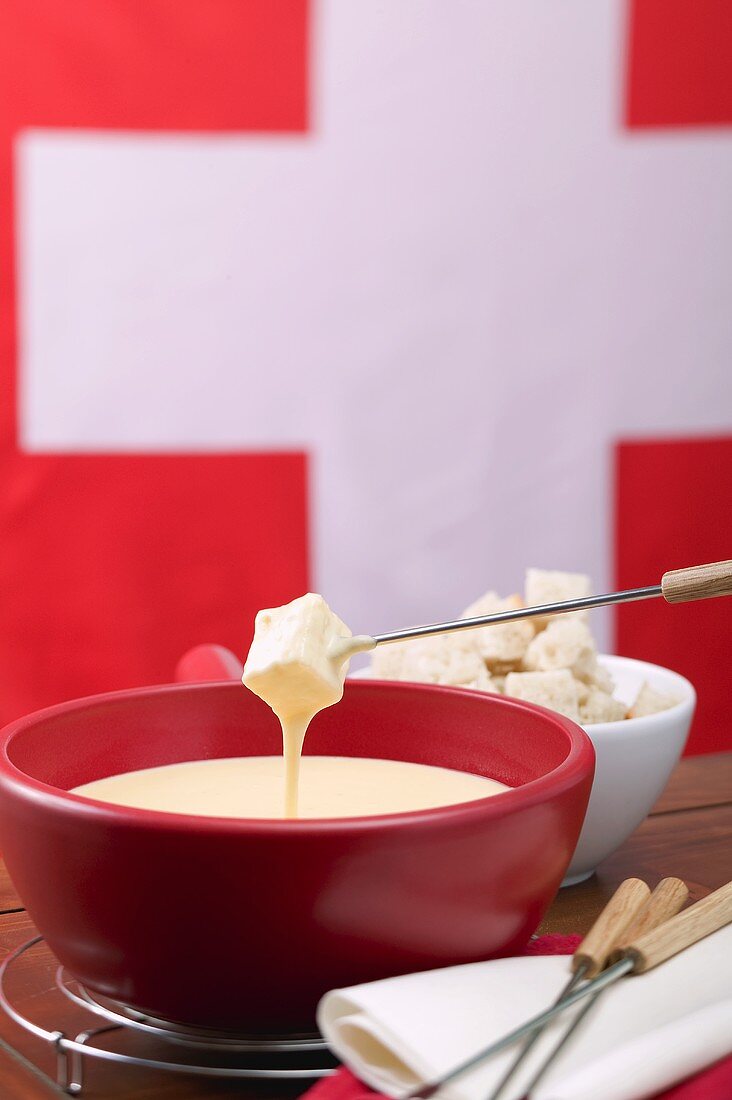 Cheese fondue in front of Swiss flag