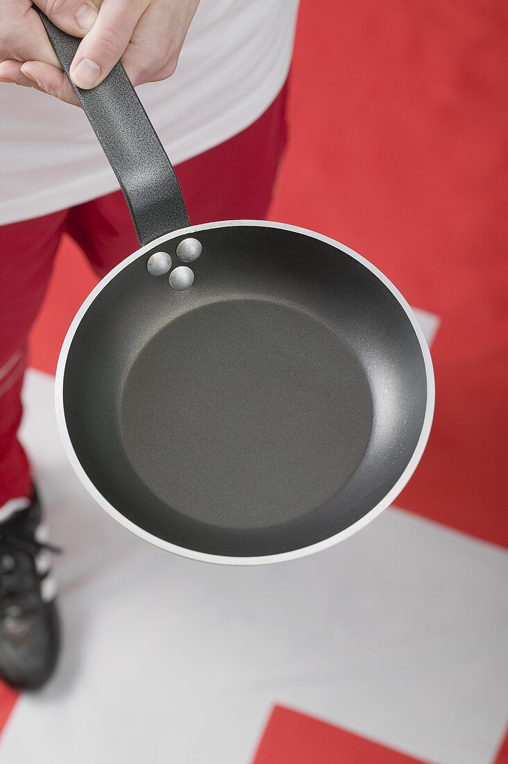 Footballer on Swiss flag holding frying pan