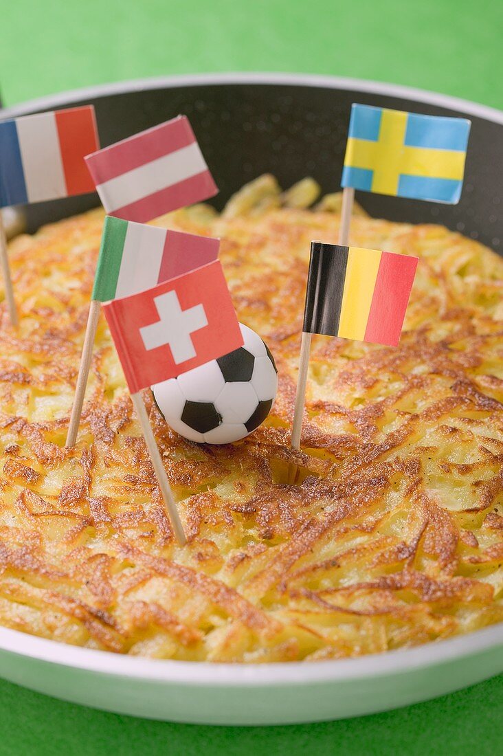 Rösti mit Minifussball und europäischen Flaggen in Pfanne