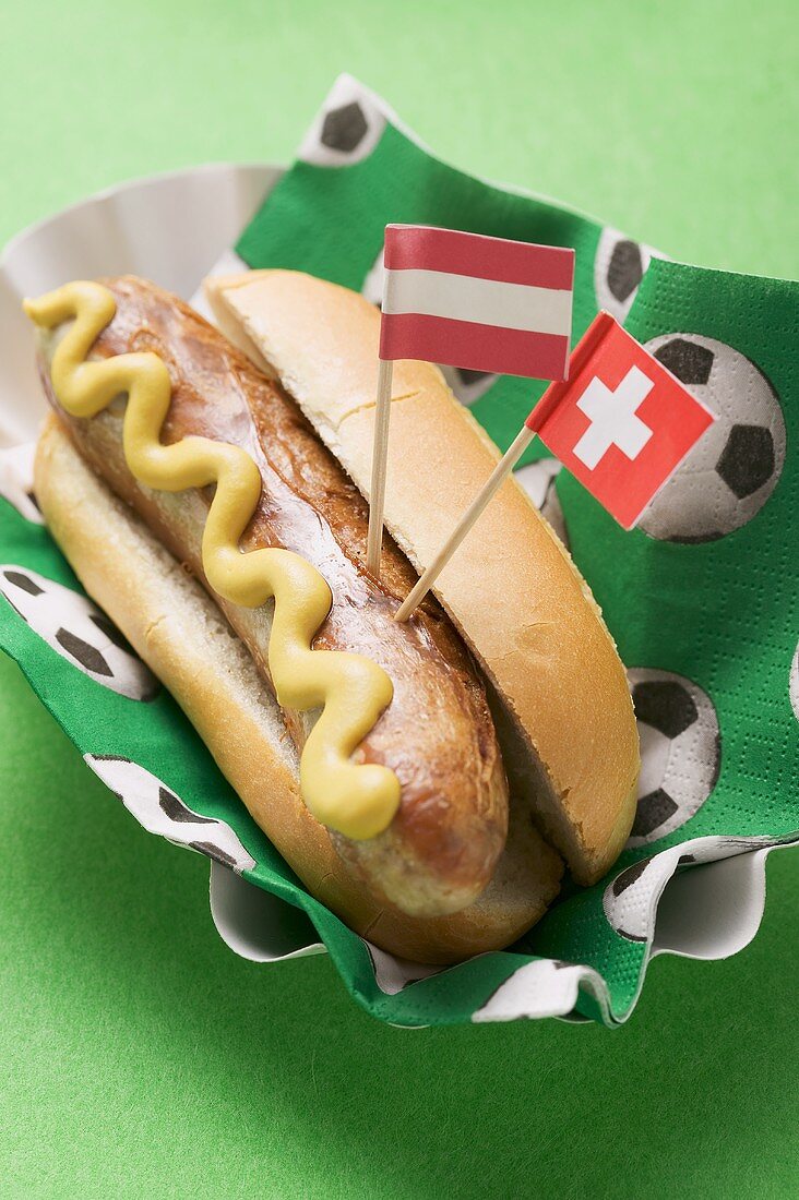 Hot dog with mustard & flags on napkin with football motifs