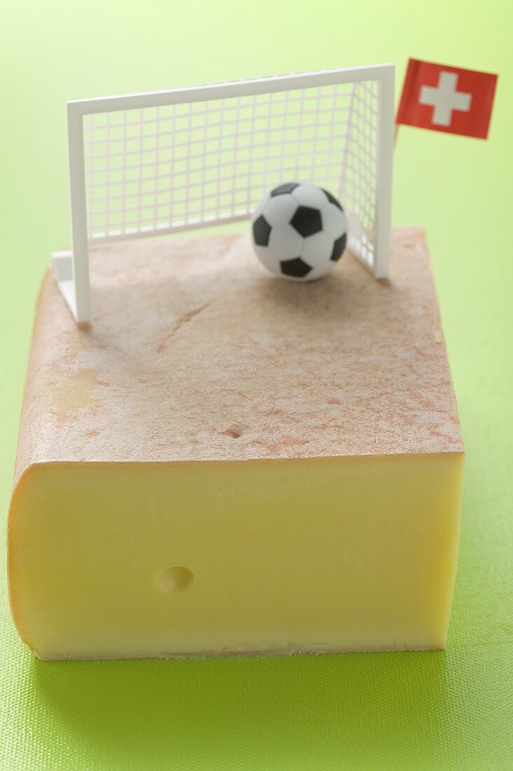 Swiss raclette cheese with football decoration and flag
