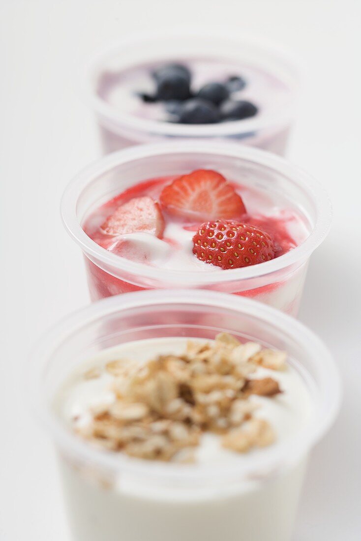 Three yoghurts with berries and cereal