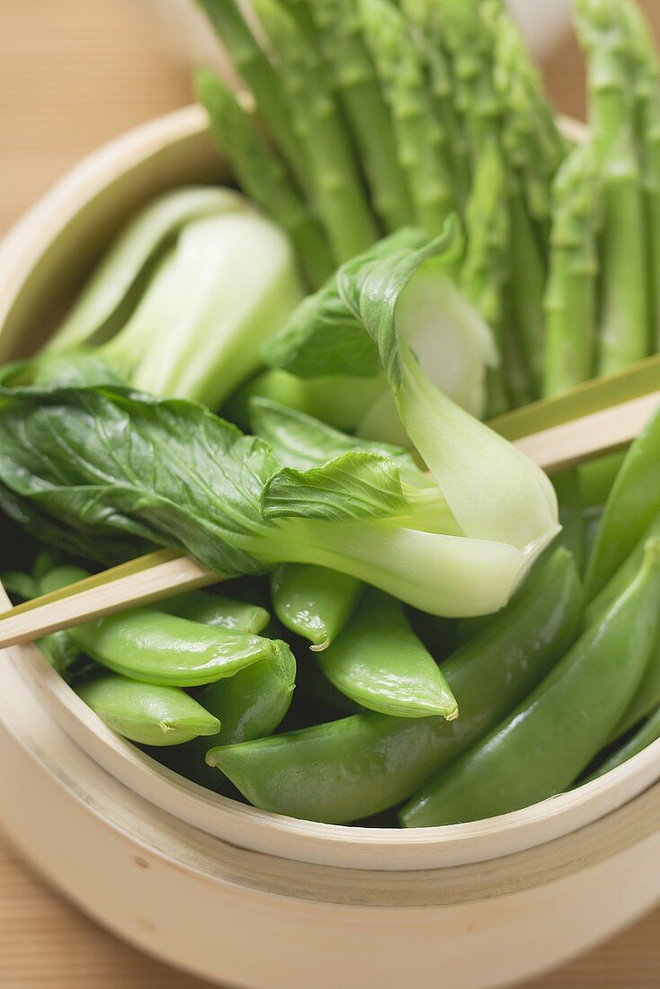 Pak choi, sugar snap peas & asparagus in bamboo steamer (Asia)