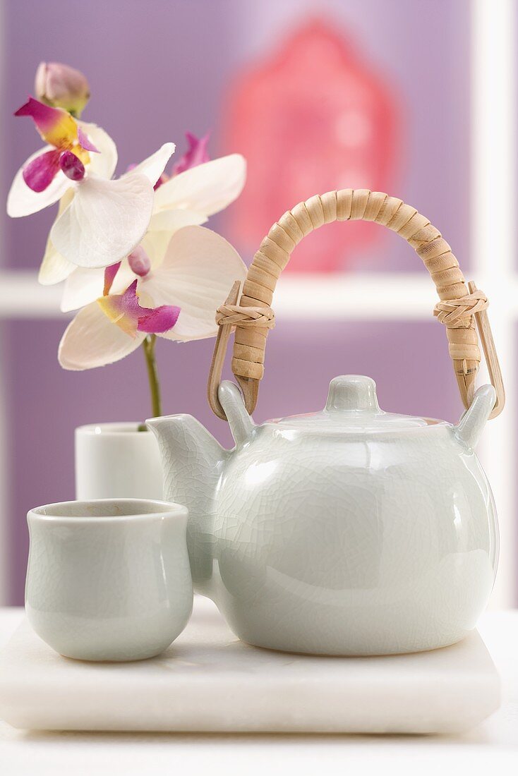 Teekanne, Teeschale und Orchidee