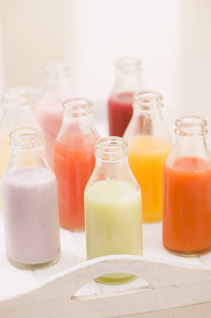 Various different juices in small bottles on tray